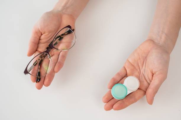 istock A woman makes a choice between lenses and glasses. 2167820187