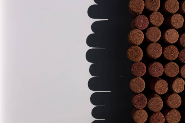 Wine corks on white background, stylish card with copy space for text and deep shadows of shots corks, concept for wine sphere, production and sales
