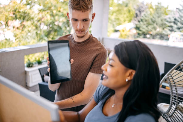 istock University students preparing for exam together at balcony at home writing on white board and showing tablet screen 2167822580