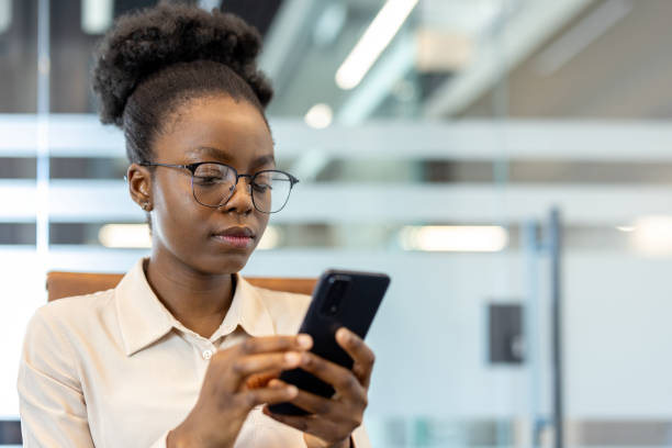 istock Young african american businesswoman using smartphone at workplace inside modern office 2167823232