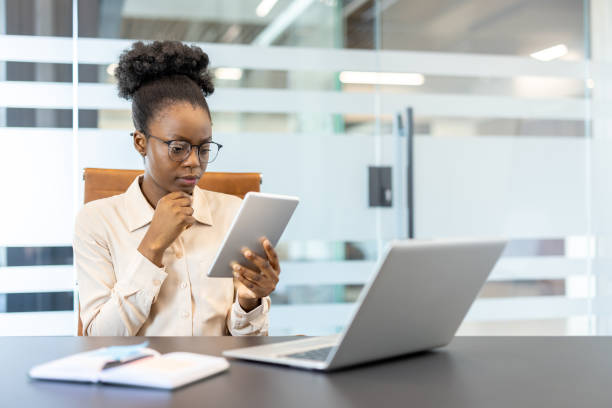 istock Focused businesswoman using digital tablet in modern office setting 2167824916