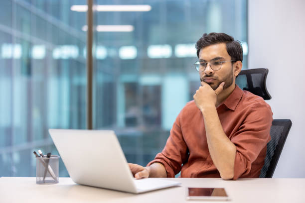 istock Serious businessman working on laptop in modern office, contemplating and analyzing data 2167826913