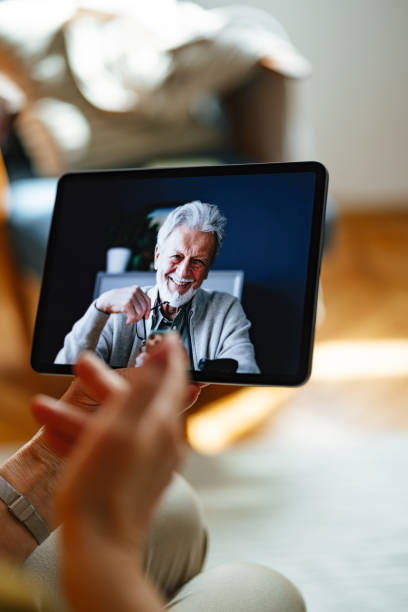 istock Senior Caregiver Communicating with Elderly Man via Tablet Technology 2167829431