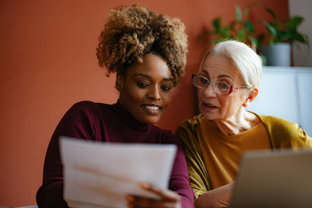 istock Senior Woman and Caregiver Discussing Documents Together 2167829486