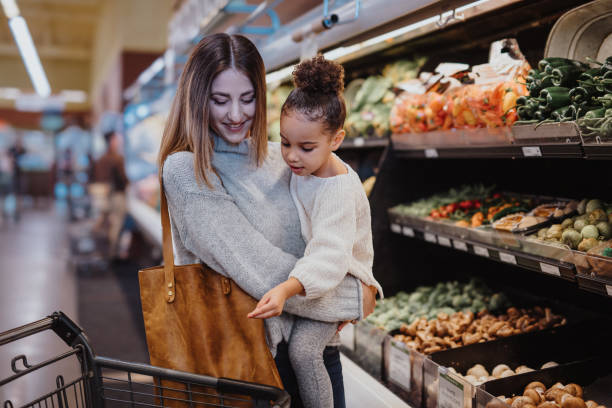 istock Mother holds her daughter while grocery shopping 2167830362