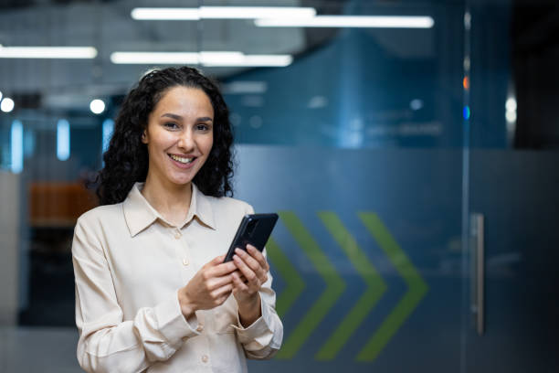 istock Smiling businesswoman using smartphone in modern office environment 2167830895