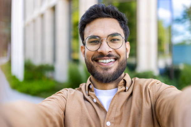 istock Smiling man taking selfie outdoors on sunny day 2167832138