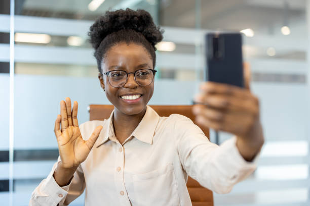 istock Smiling woman waving during video call using smartphone in modern office 2167835088