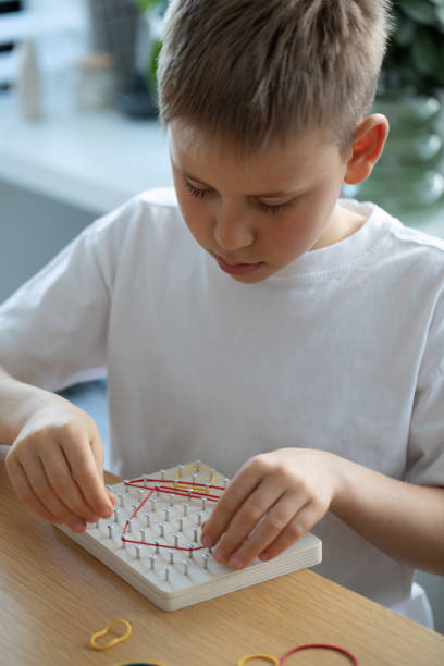 istock A Child Actively Engaged in a Fun Creative Rubber Band Art Activity Within His Home Environment 2167836875