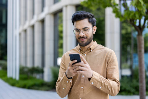 istock Businessman using smartphone outside office building, modern professional lifestyle 2167837092