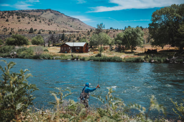 istock Fisherman stands on the riverbank to fly fish 2167840698
