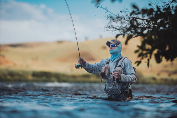 istock Fisherman stands waist deep in the river while fishing 2167840849