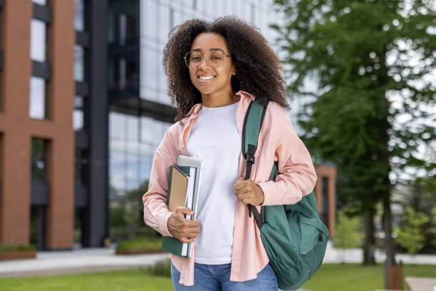 istock Happy female student walking on campus with backpack and books, smiling confidently 2167840877