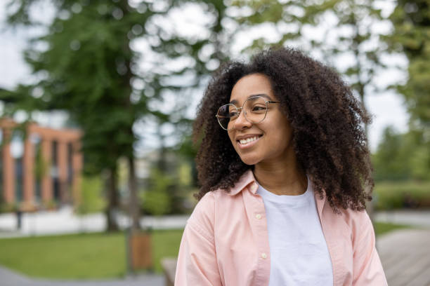 istock Young female student smiling outdoors near university campus on a bright day 2167841646