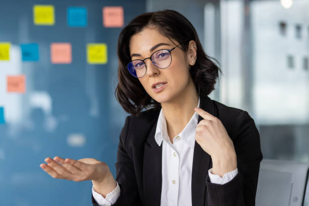 istock Businesswoman explaining concept during video call in modern office setting 2167841745
