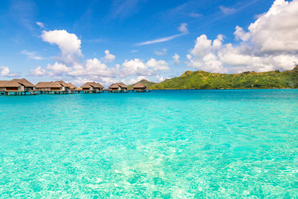 Bora Bora, Tahiti - December 8, 2022: Luxury overwater bungalows in a vacation resort in the clear blue lagoon with a view on the tropical island of Bora Bora, near Tahiti, in French Polynesia.