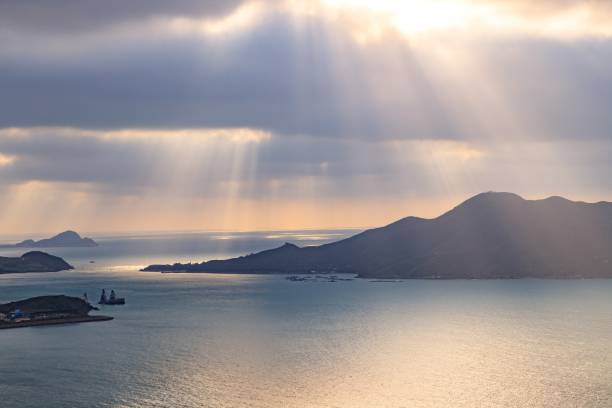 Sunbeams Breaking Through Clouds Over Serene Ocean