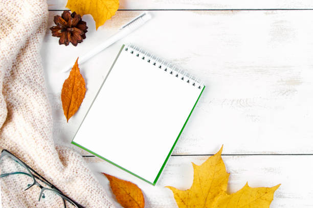 istock Hello autumn. Yellow leaves, notepad and glasses. Stylish workspace. Flat lay composition on white wooden background. 2167845052