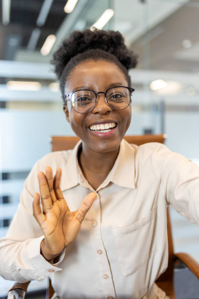 istock Smiling woman waving during video call in modern office environment 2167845951