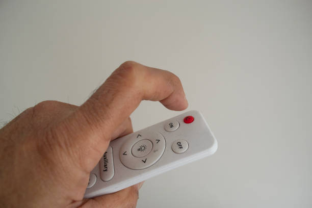 istock a man's hand with a remote control of a lamp 2167845966