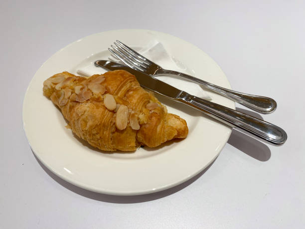 istock Almond Croissant on a White Plate with Fork and Knife 2167846839