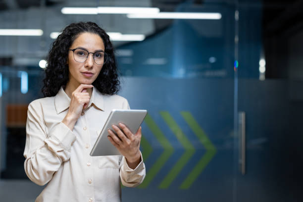 istock Confident female office worker with tablet in modern office setting 2167849186