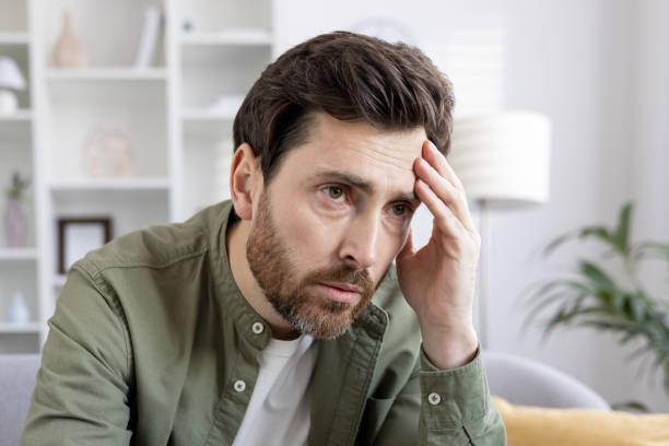 istock Man feeling stressed and worried at home holding head with hand 2167850174