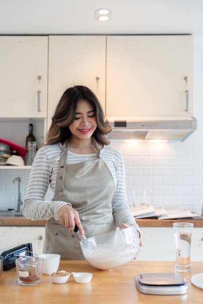 istock Smiling Woman Baking in Home Kitchen with Mixing Bowl and Ingredients 2167850657