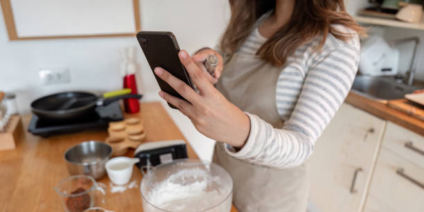istock Woman Following Recipe on Smartphone While Baking at Home 2167850670