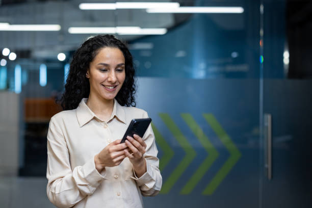 istock Happy businesswoman using smartphone while standing in modern office environment 2167851317
