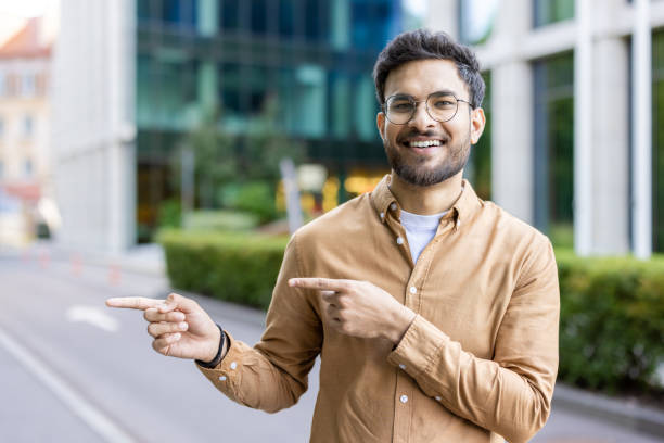 istock Smiling man pointing in opposite directions outside modern office buildings 2167851728