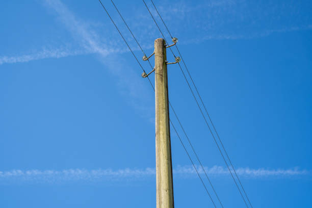 Wooden pole with power lines in the blue sky