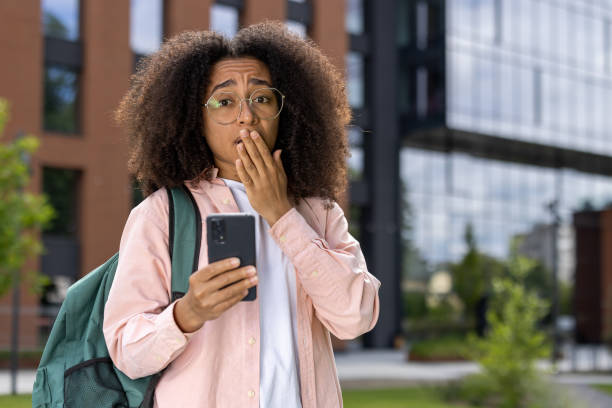 istock Surprised young student with smartphone in urban environment 2167852493