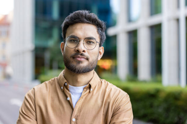 istock Confident young man with glasses standing outdoors in urban setting 2167853737