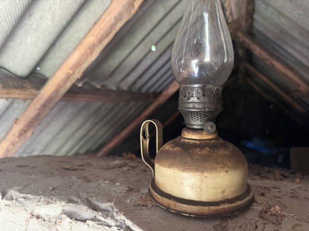 An old kerosene lamp with a glass shade. Inside a room covered with slate.