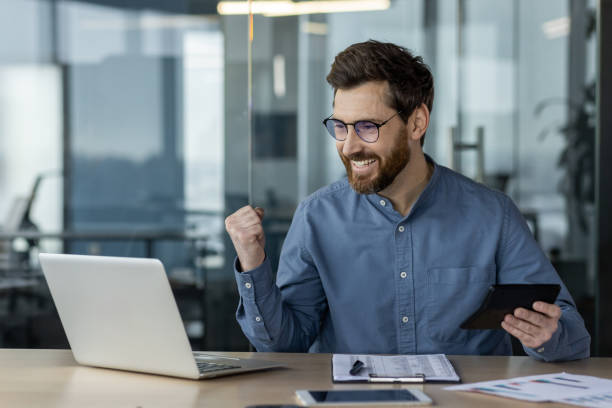 istock Happy financier working on laptop using calculator and phone in modern office 2167856120