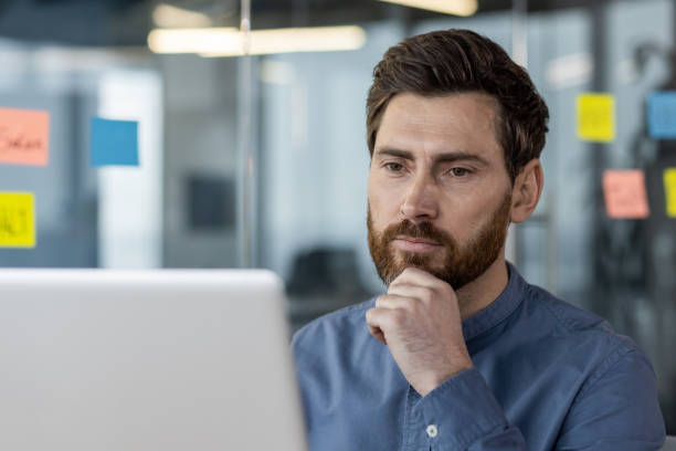 istock Focused businessman concentrating on laptop in modern office setting 2167856964
