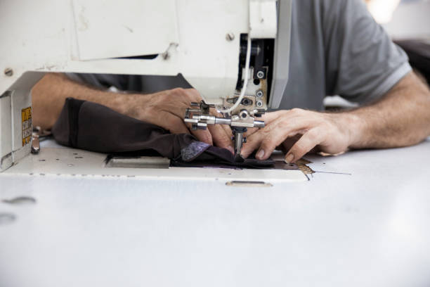 istock Close-up Front View Of Man Sewing Leather Clothes On Sewing Machine In Textile Workshop 2167857638
