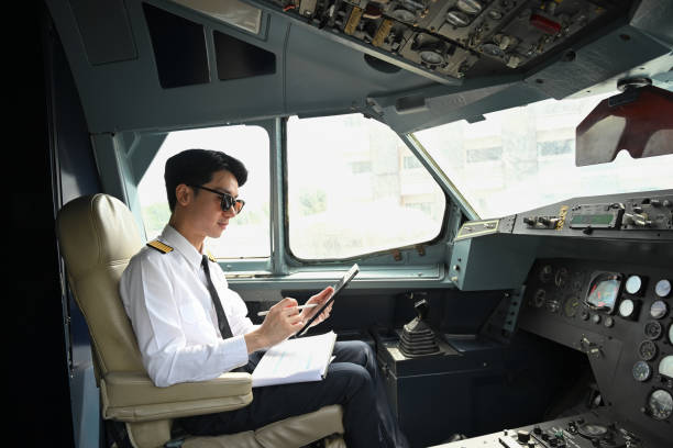 istock Handsome pilot wearing sunglasses using digital tablet, preparing for flight in the cockpit of an aircraft 2167858876