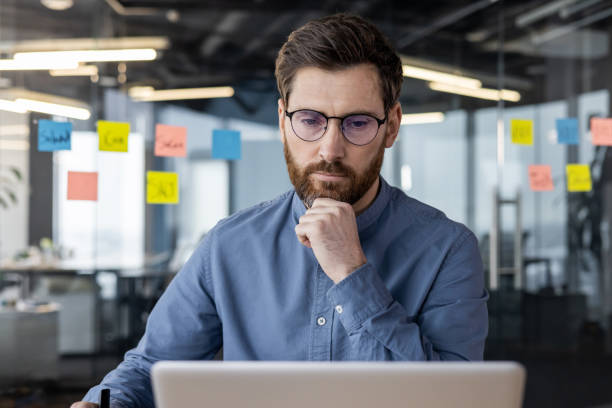 istock Focused male professional working on laptop in modern office environment 2167859010