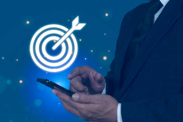 istock Businessman hand using smartphone touching to target dart board icon with arrow for setup and achievement objectives target, strategy, planning, development for business investment concept. 2167860642