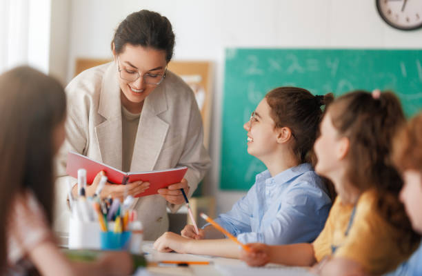 istock Happy kids and teacher at school 2167862596