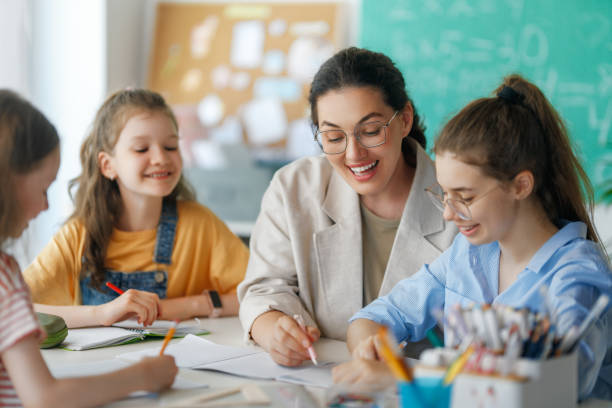 istock Happy kids and teacher at school 2167862631
