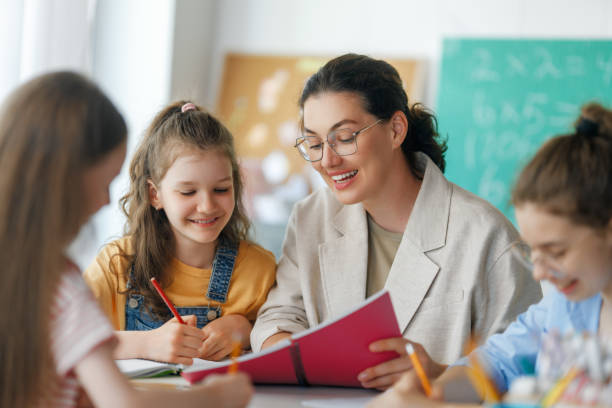istock Happy kids and teacher at school 2167862663