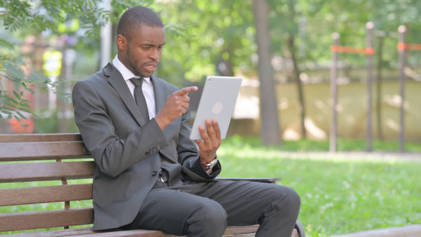 istock African Businessman Doing Video Chat on Tablet Outdoor 2167863490