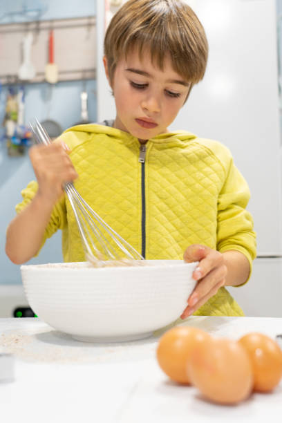 istock Child mixing cake batter in a bowl with a manual kitchen whisk 2167863546