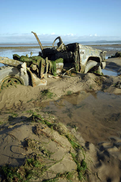 istock Abandoned 4x4 sunk into sand on beach. 2167867215