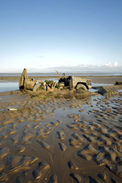istock Abandoned 4x4 sunk into sand on beach. 2167867217