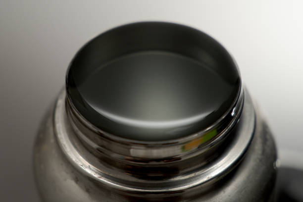 Water surface tension seen on top of a filled insulated drink container, physics