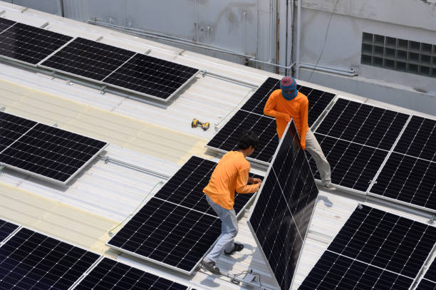 istock Worker installs solar panels. Worker installs solar panels at a solar farm field. 2167871580